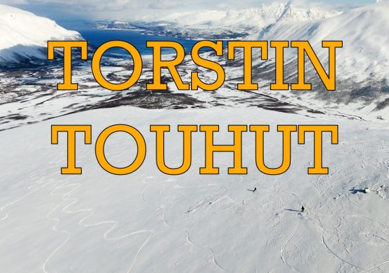 Kansikuva Torstin Touhut -kanavalle. Panoraamakuva lumisesta Lyngen-vuoristosta Norjassa. Kuvan etualalla avara laskettelurinne ja kaksi pientä vapaalaskijaa. Taustalla näkyy vuono ja vuoria. Keskellä kuvaa oranssilla tekstillä Torstin Touhut